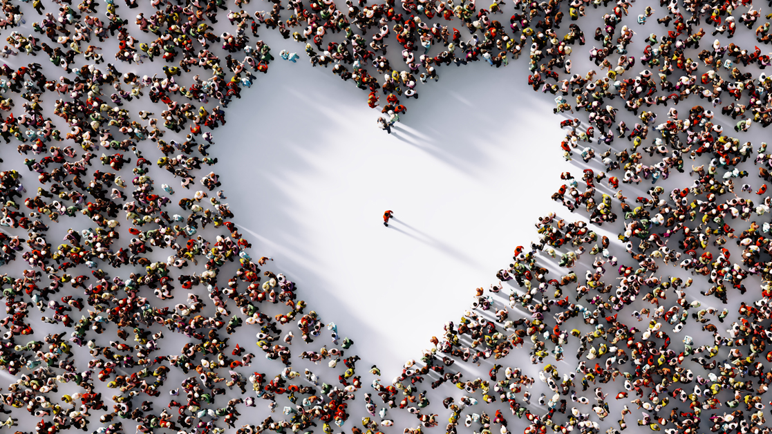 Lone man standing in a white heart shaped void formed by a surrounding crowd