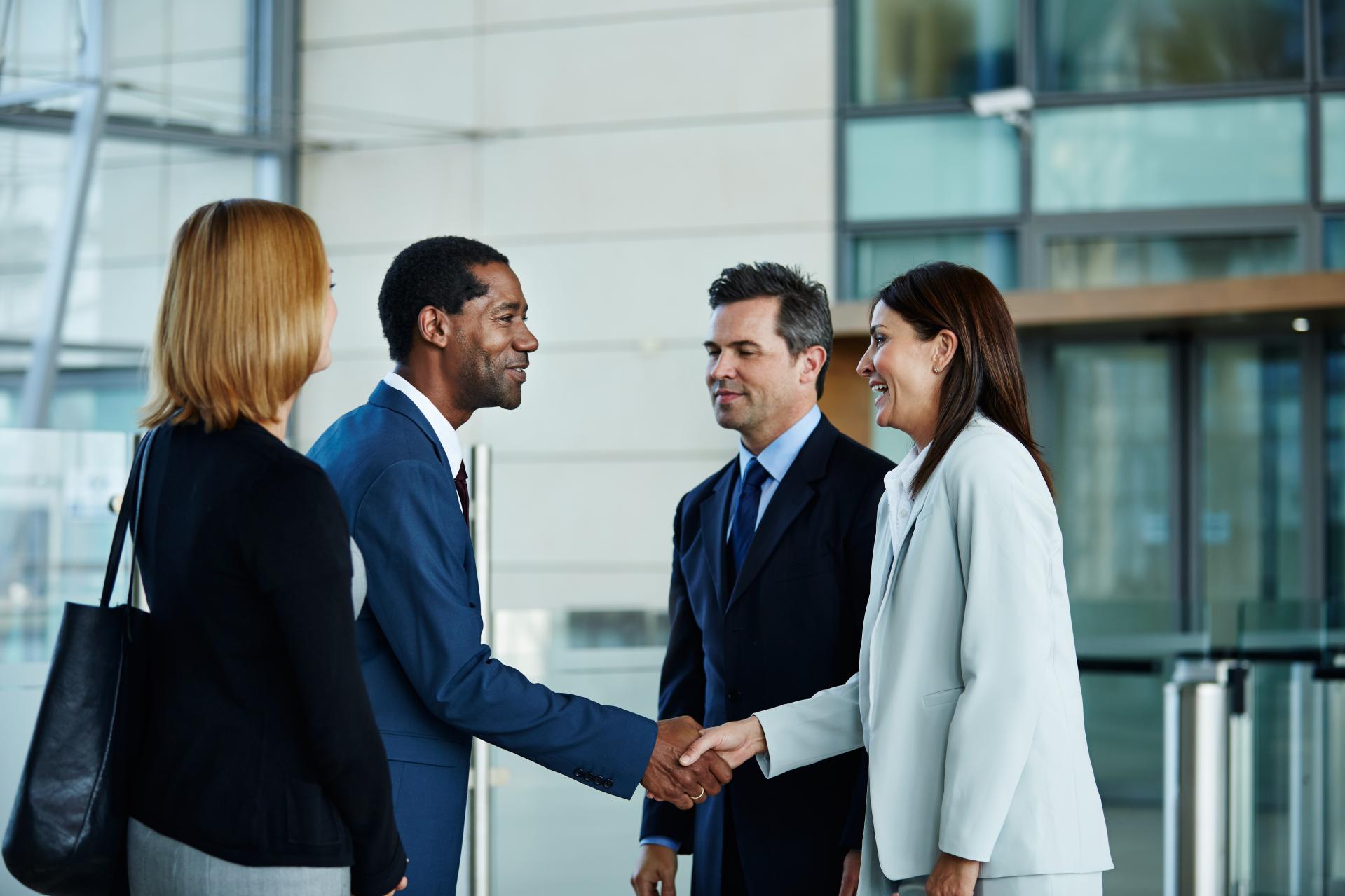 Four people meeting and shaking hands