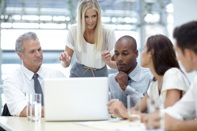 Team of business people gathered around laptop